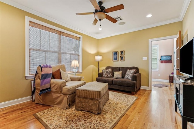 living room featuring light wood-style floors, baseboards, visible vents, and ornamental molding