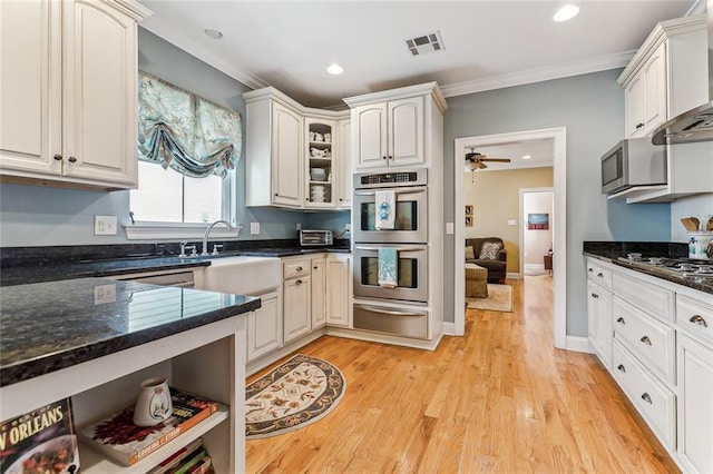 kitchen with visible vents, appliances with stainless steel finishes, ornamental molding, a warming drawer, and light wood finished floors