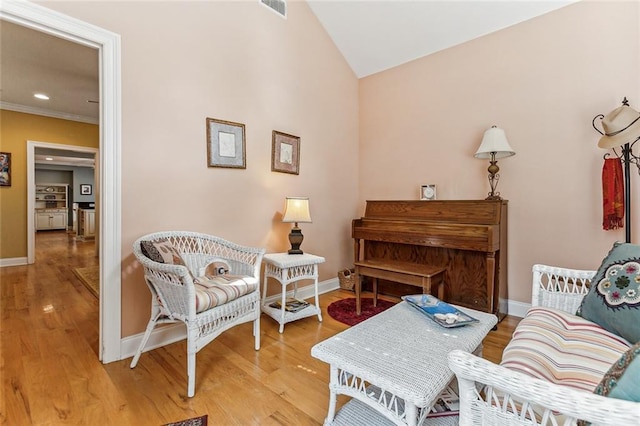 sitting room with baseboards, visible vents, and wood finished floors