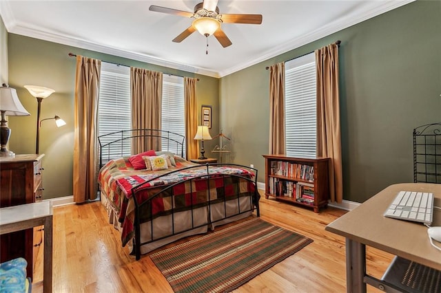 bedroom with a ceiling fan, light wood-style flooring, baseboards, and crown molding