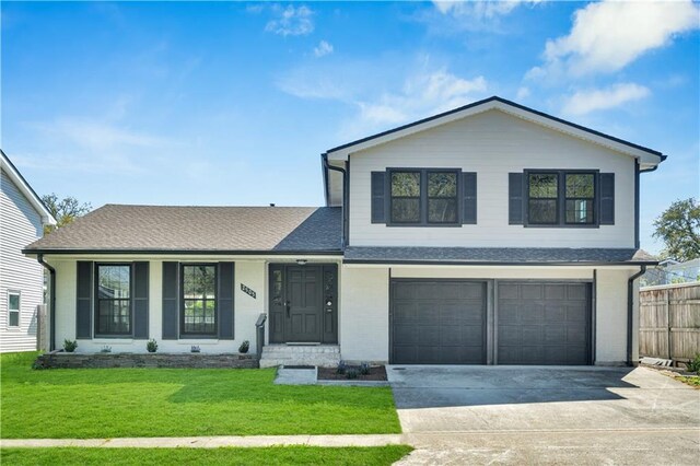 view of front of house with covered porch, a garage, and a front lawn