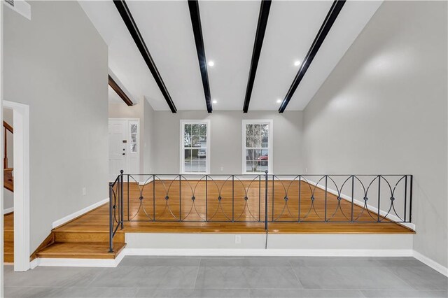 unfurnished living room with high vaulted ceiling and beamed ceiling