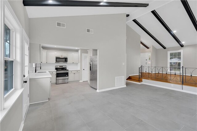 kitchen with light tile patterned flooring, stainless steel appliances, sink, and white cabinets