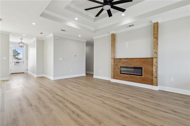 unfurnished living room featuring a raised ceiling, crown molding, light hardwood / wood-style flooring, and ceiling fan with notable chandelier