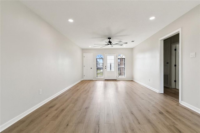 empty room with ceiling fan and light hardwood / wood-style flooring