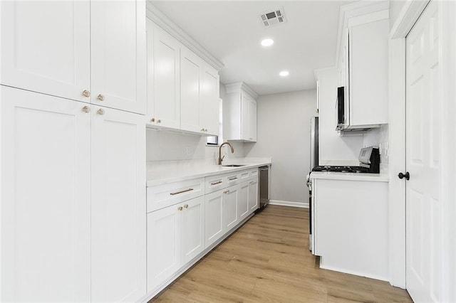 kitchen featuring sink, white cabinets, white range with gas stovetop, and light hardwood / wood-style flooring