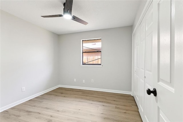 unfurnished bedroom with ceiling fan, a closet, and light wood-type flooring