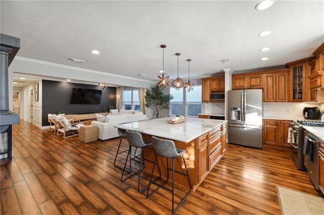 kitchen with pendant lighting, a breakfast bar, backsplash, appliances with stainless steel finishes, and a kitchen island