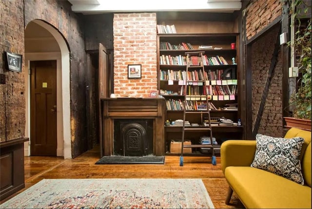 unfurnished room with built in features, wood-type flooring, and a wood stove