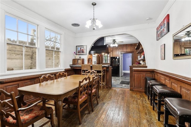 dining area with crown molding, dark hardwood / wood-style floors, and ceiling fan with notable chandelier