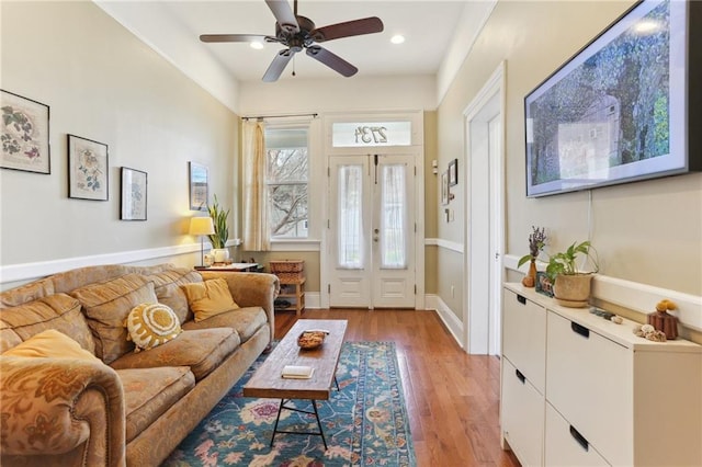 living room featuring ceiling fan, french doors, and light hardwood / wood-style floors