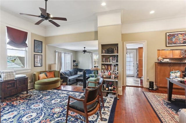 living room featuring ceiling fan, dark hardwood / wood-style flooring, and crown molding