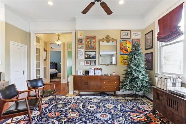 living area featuring dark hardwood / wood-style flooring, ceiling fan, and ornamental molding