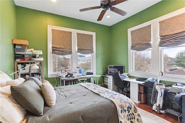 bedroom with multiple windows, ceiling fan, and wood-type flooring