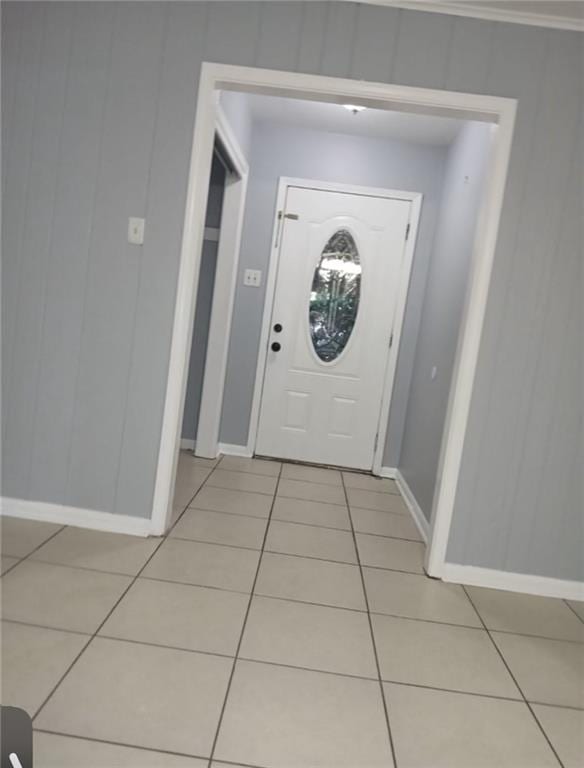 foyer entrance featuring light tile patterned floors, baseboards, and ornamental molding