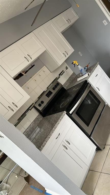 kitchen with a textured ceiling and light tile patterned flooring