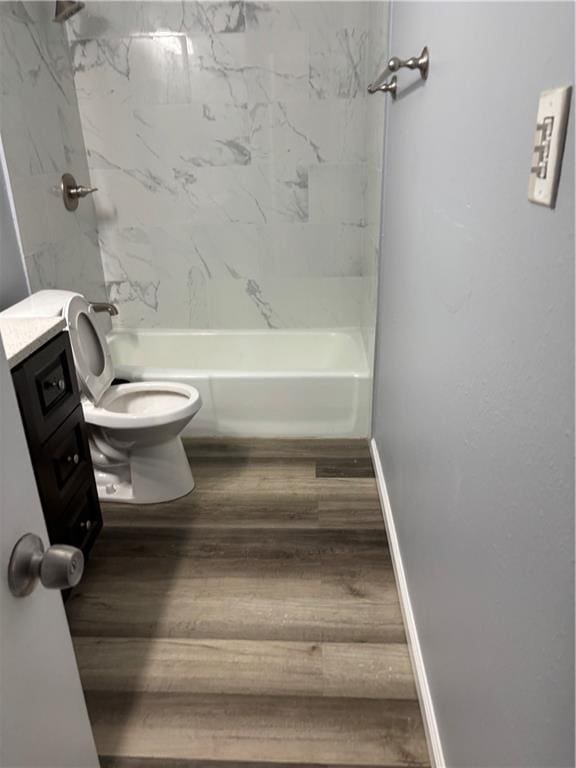 full bath with vanity, wood finished floors, baseboards, shower / washtub combination, and toilet