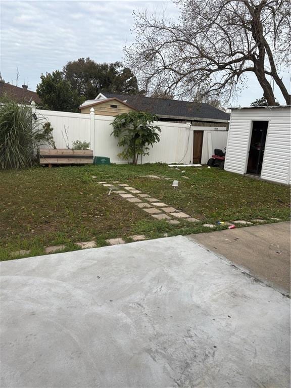 view of yard with a storage shed, an outdoor structure, and fence