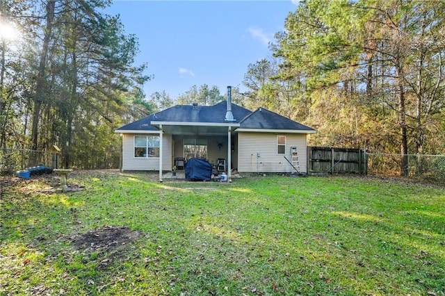 back of house with a patio area and a lawn