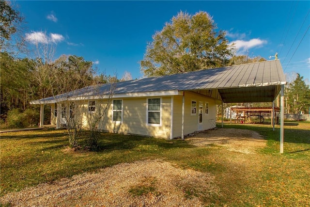 view of side of home with a carport and a yard