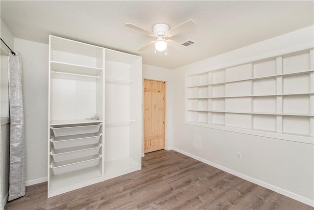 unfurnished bedroom featuring wood-type flooring, a closet, and ceiling fan