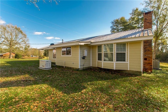 back of property with a lawn and cooling unit