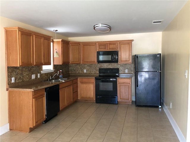 kitchen featuring black appliances, pendant lighting, light tile patterned floors, and sink