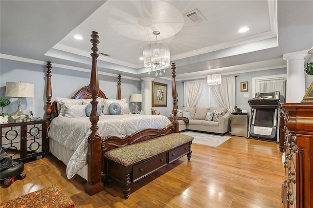 bedroom with a tray ceiling, crown molding, and an inviting chandelier