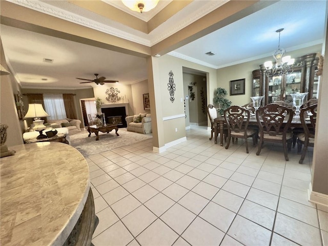 dining space with ceiling fan with notable chandelier, ornamental molding, and light tile patterned floors