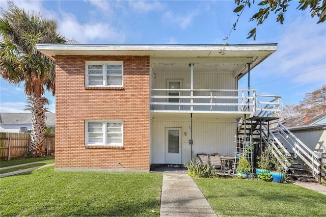 view of front facade featuring a balcony and a front lawn