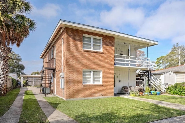 rear view of property with a balcony, a yard, and central air condition unit