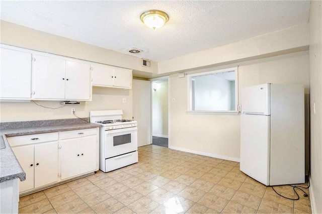 kitchen featuring white cabinets, a textured ceiling, and white appliances