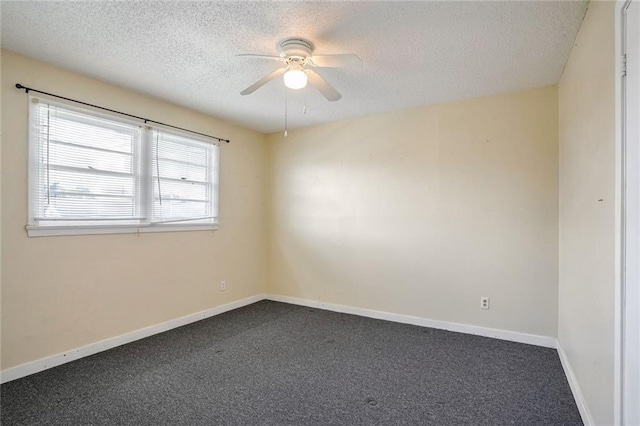 spare room featuring ceiling fan, dark carpet, and a textured ceiling