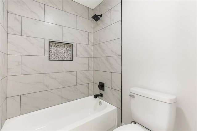 bathroom with toilet and tiled shower / bath