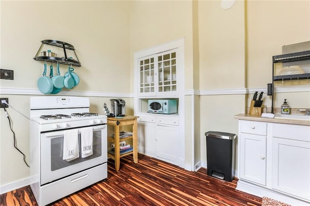 kitchen featuring white appliances, dark hardwood / wood-style floors, and white cabinetry