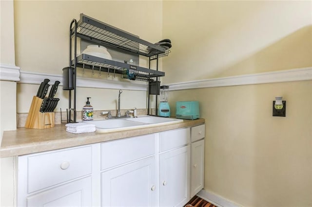 bar with white cabinetry and sink