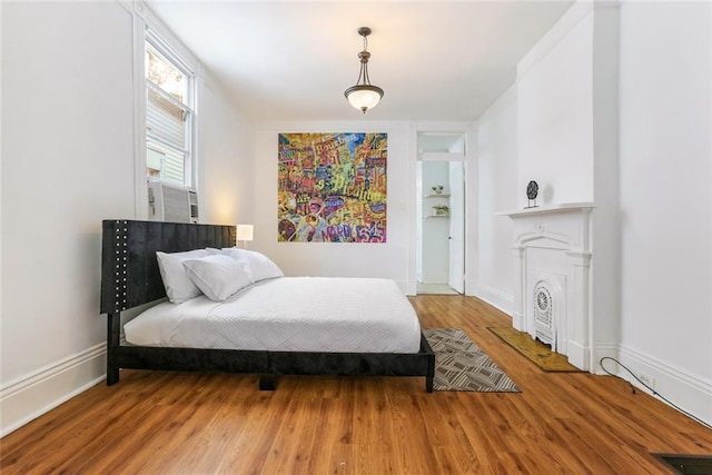 bedroom with wood-type flooring and cooling unit