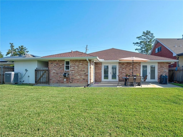 rear view of property with french doors, a patio, central AC, and a lawn