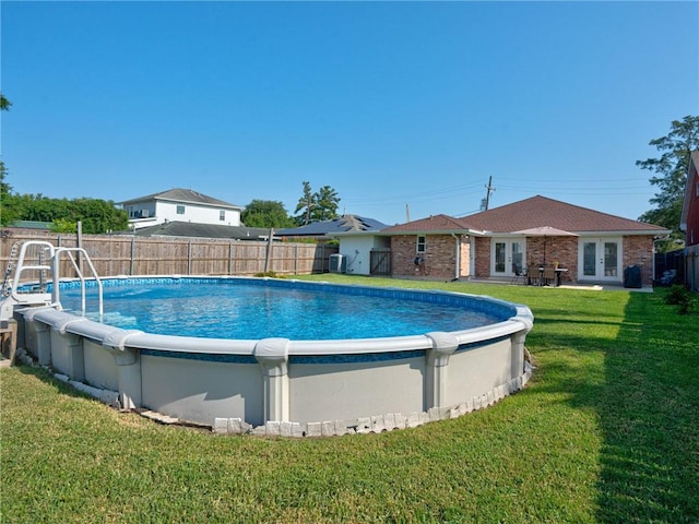 view of pool with a yard and french doors