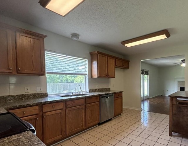 kitchen featuring sink, stainless steel dishwasher, ceiling fan, light tile patterned floors, and a textured ceiling