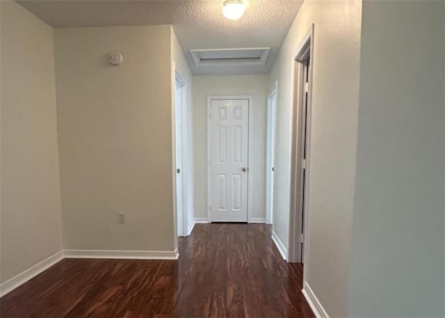 corridor featuring dark hardwood / wood-style flooring and a textured ceiling