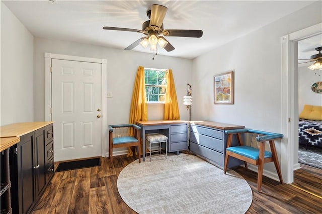 living area featuring ceiling fan, dark hardwood / wood-style floors, and built in desk