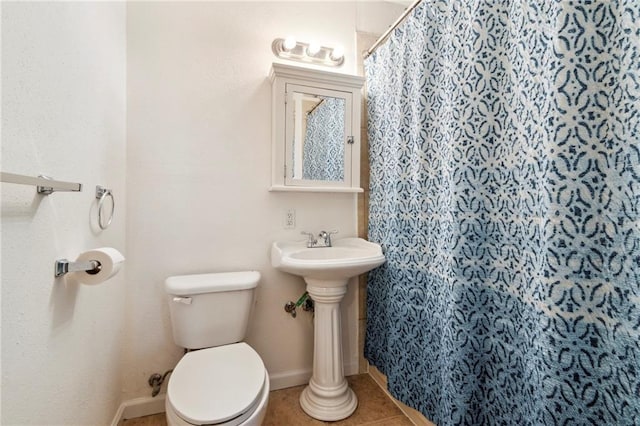 bathroom featuring tile patterned flooring, curtained shower, and toilet