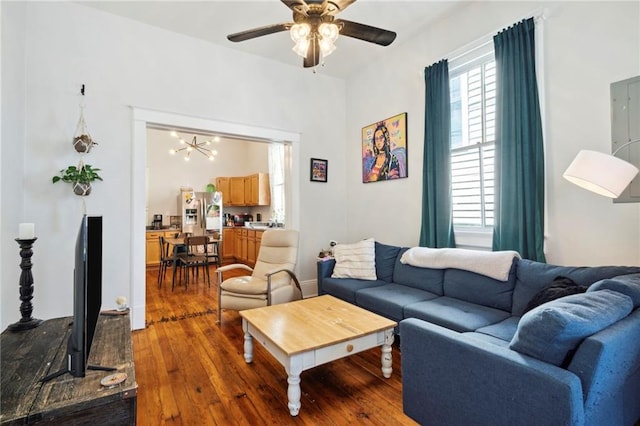 living room featuring hardwood / wood-style floors and ceiling fan with notable chandelier