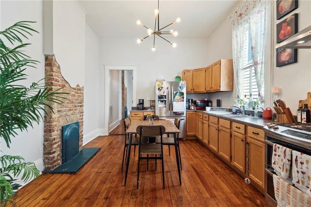 kitchen featuring sink, dark hardwood / wood-style flooring, stainless steel appliances, and an inviting chandelier