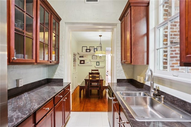 kitchen with dishwasher, light tile patterned floors, hanging light fixtures, and sink