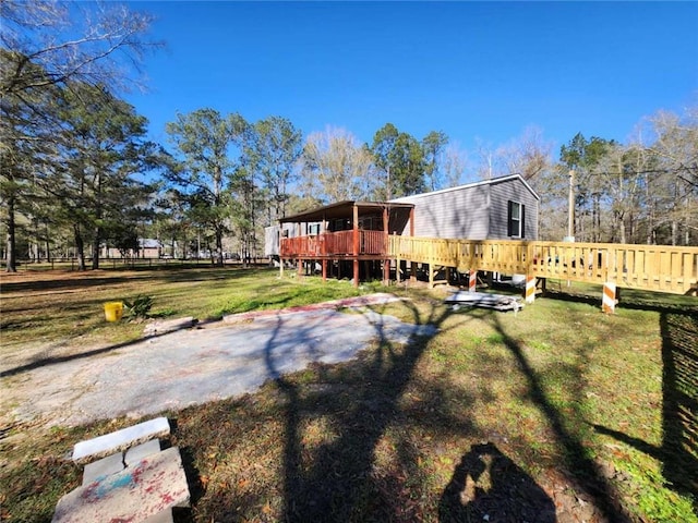 rear view of house with a yard and a wooden deck