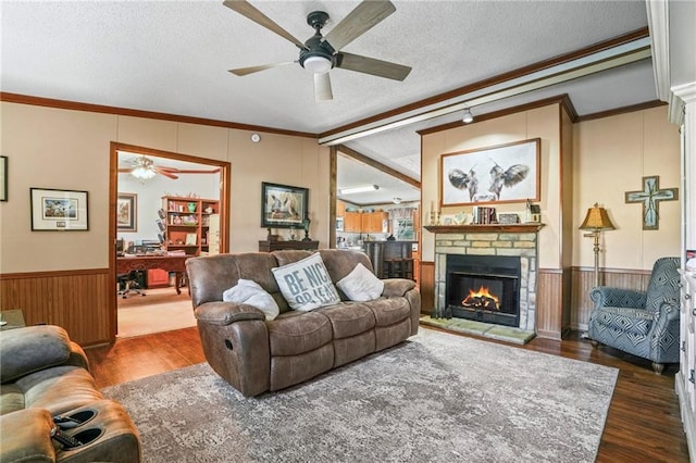 living room with a fireplace, a textured ceiling, dark hardwood / wood-style floors, and ornamental molding