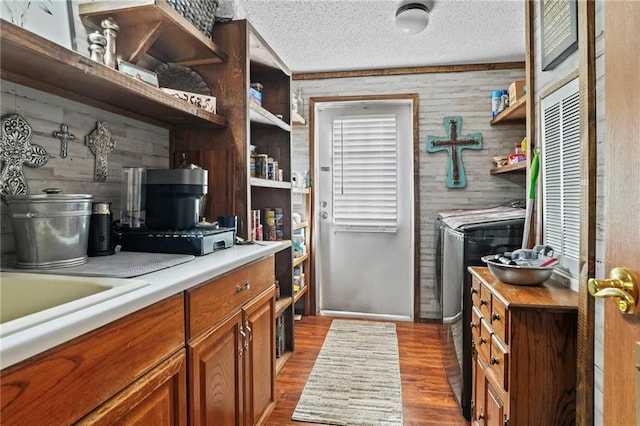 kitchen featuring hardwood / wood-style flooring, a textured ceiling, and wooden walls