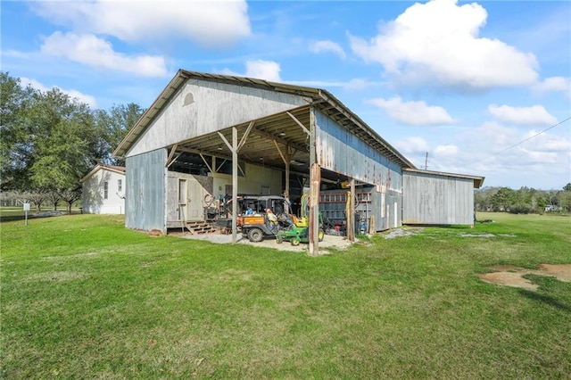 rear view of house featuring a yard and an outdoor structure